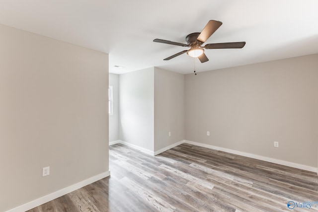 empty room with baseboards, ceiling fan, and wood finished floors