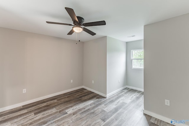 empty room featuring baseboards, ceiling fan, and wood finished floors