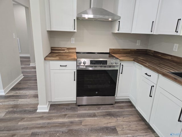 kitchen featuring butcher block countertops, dark wood-style floors, wall chimney exhaust hood, and stainless steel range with electric cooktop