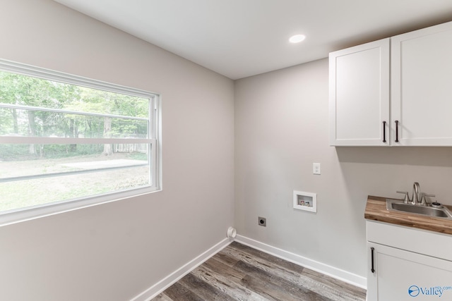 laundry area with electric dryer hookup, cabinet space, wood finished floors, a sink, and hookup for a washing machine