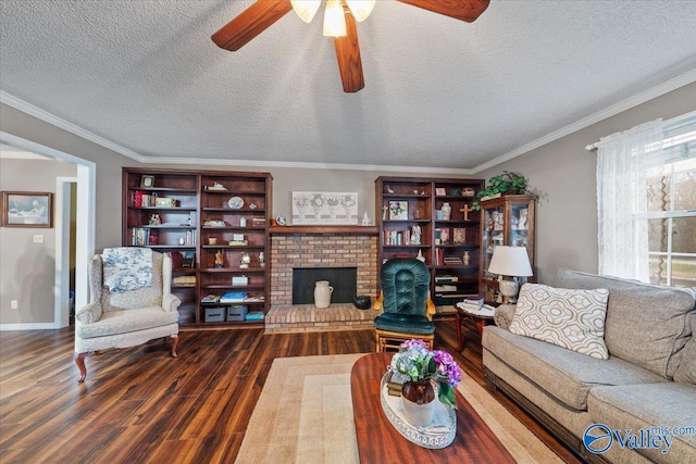 living room featuring dark hardwood / wood-style flooring, a fireplace, ornamental molding, and a textured ceiling