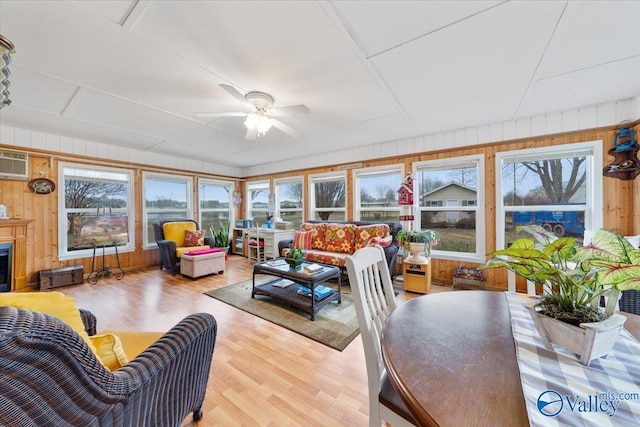 sunroom with a wall mounted AC and ceiling fan