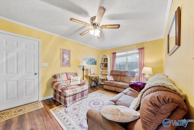 living room with crown molding, ceiling fan, wood-type flooring, and a textured ceiling