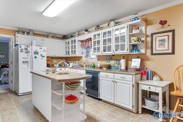 kitchen featuring white cabinetry, white fridge with ice dispenser, black dishwasher, and a center island with sink