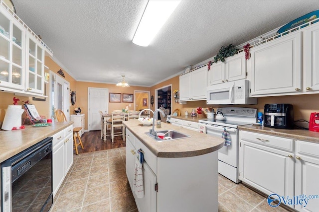 kitchen with sink, white appliances, white cabinetry, a textured ceiling, and a center island with sink