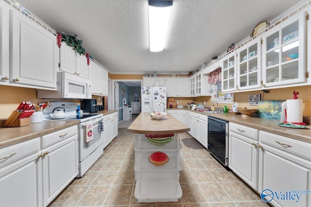 kitchen featuring white appliances, a kitchen island, and white cabinets