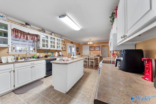 kitchen featuring sink, dishwasher, white cabinetry, a center island, and a textured ceiling