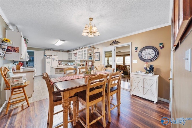 dining space featuring ornamental molding, dark hardwood / wood-style floors, a textured ceiling, and a notable chandelier