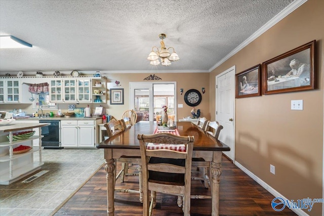 dining space featuring ornamental molding, sink, a textured ceiling, and an inviting chandelier