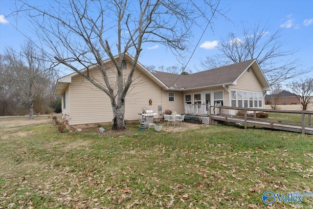 rear view of property featuring a yard and a deck