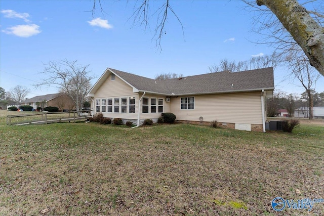 rear view of property with a sunroom and a lawn