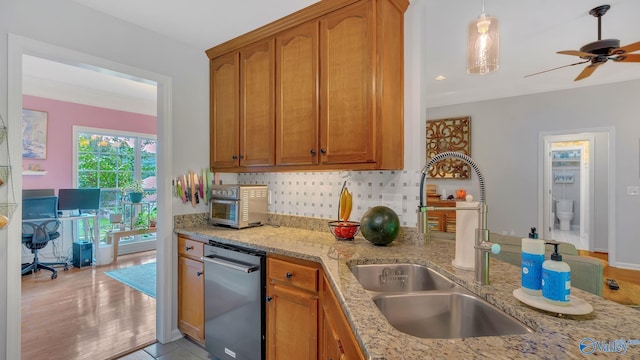 2317 Little Cove Rd, Owens Cross Roads, AL 35763 - kitchen with dishwashing machine, light stone counters, tasteful backsplash, brown cabinetry, and a ceiling fan