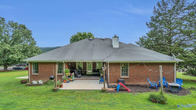 2317 Little Cove Rd, Owens Cross Roads, AL 35763 - back of house with a lawn, a patio, a chimney, and brick siding