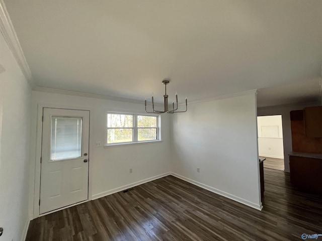 unfurnished dining area with crown molding, a chandelier, dark wood finished floors, and baseboards