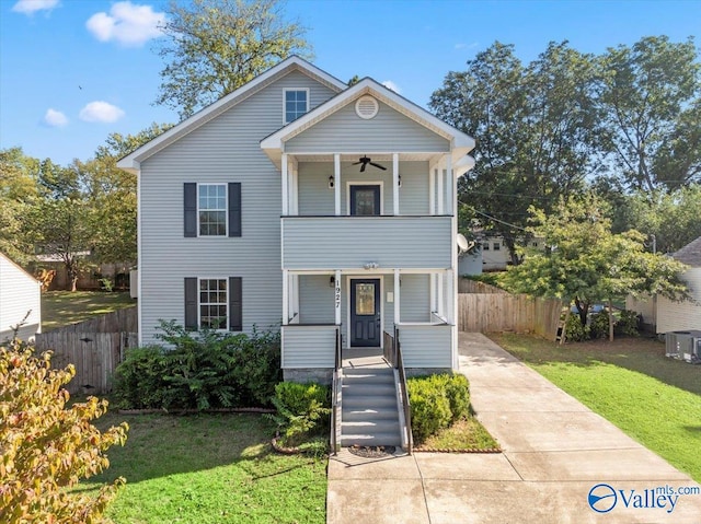 view of front of home featuring ceiling fan, covered porch, and a front yard