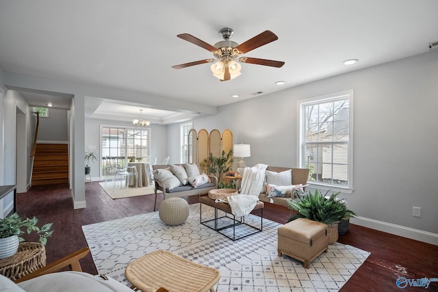 living area with baseboards, stairway, a healthy amount of sunlight, and wood finished floors