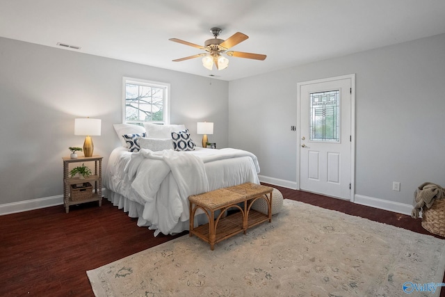 bedroom with baseboards, visible vents, and wood finished floors