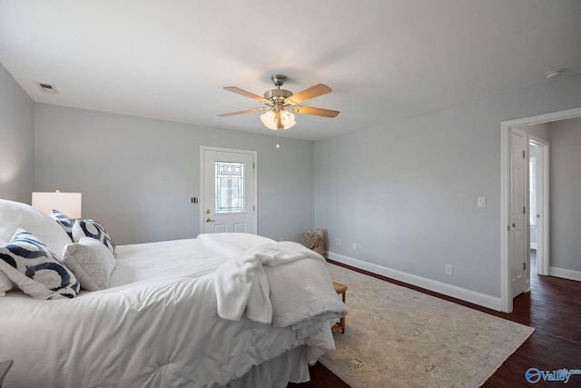 bedroom with baseboards, a ceiling fan, visible vents, and wood finished floors