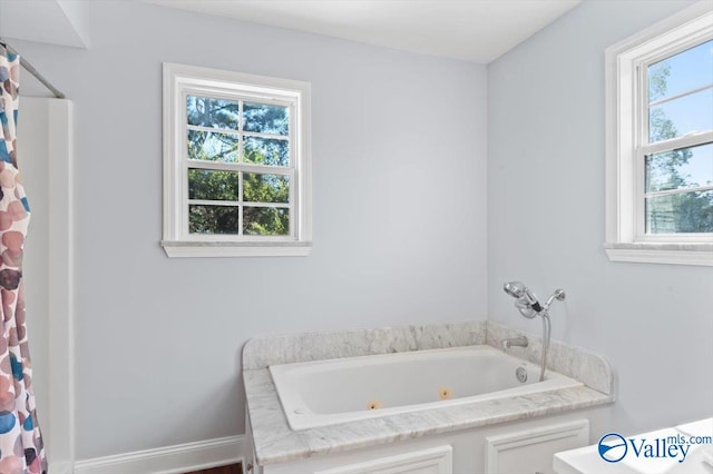 full bathroom with curtained shower and a whirlpool tub