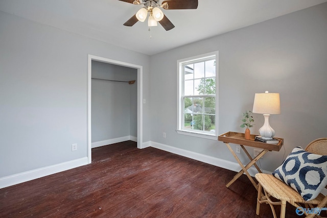 living area with wood finished floors, baseboards, and a ceiling fan