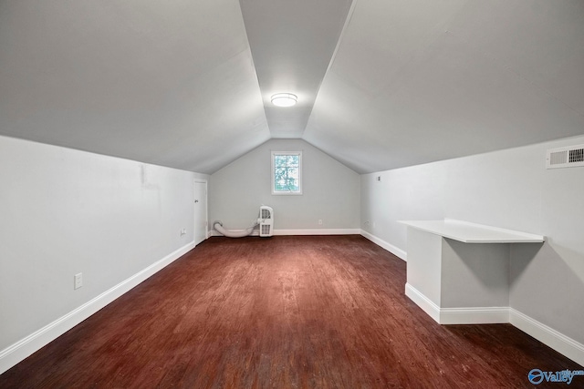 bonus room with lofted ceiling, wood finished floors, visible vents, heating unit, and baseboards