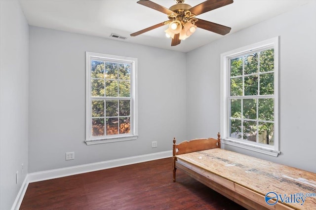 bedroom featuring multiple windows, ceiling fan, and dark hardwood / wood-style flooring