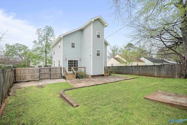 back of property featuring a gate, a patio area, a fenced backyard, a wooden deck, and a lawn