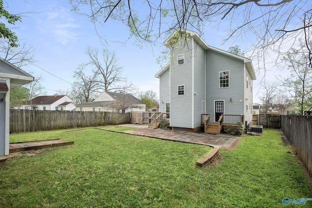 back of property featuring a lawn, cooling unit, and a fenced backyard