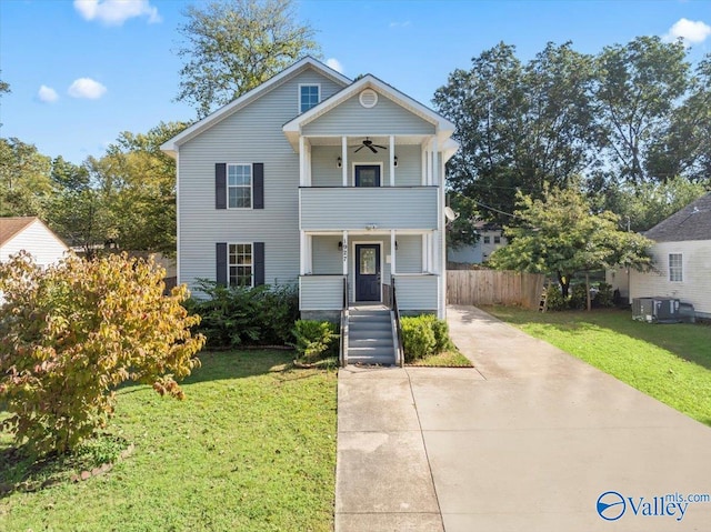 view of front of house with ceiling fan, a balcony, and a front yard