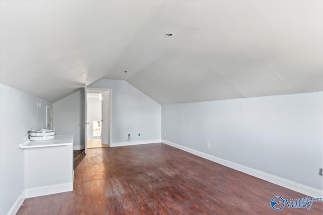 bonus room featuring dark hardwood / wood-style floors and vaulted ceiling