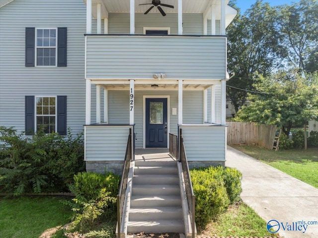 property entrance featuring ceiling fan, a balcony, and covered porch