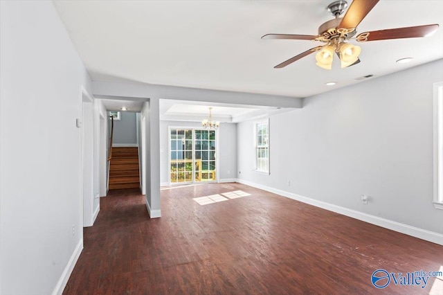 unfurnished living room with dark wood-type flooring and ceiling fan with notable chandelier