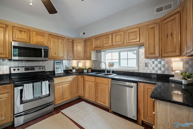 kitchen featuring appliances with stainless steel finishes, visible vents, decorative backsplash, and a sink