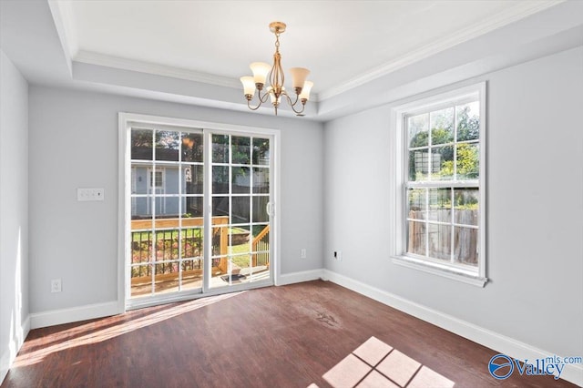 unfurnished room featuring ornamental molding, an inviting chandelier, a raised ceiling, and dark hardwood / wood-style flooring