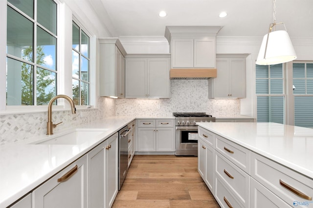 kitchen with pendant lighting, sink, appliances with stainless steel finishes, tasteful backsplash, and ornamental molding