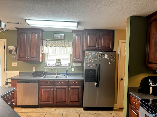 kitchen featuring light tile patterned floors, sink, stainless steel appliances, and a textured ceiling