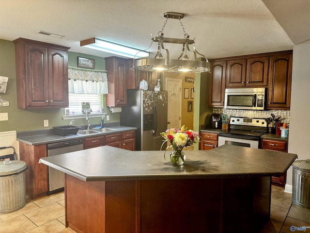 kitchen with a center island, sink, backsplash, appliances with stainless steel finishes, and light tile patterned flooring