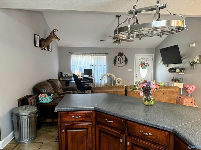 kitchen with ceiling fan, light tile patterned flooring, and lofted ceiling