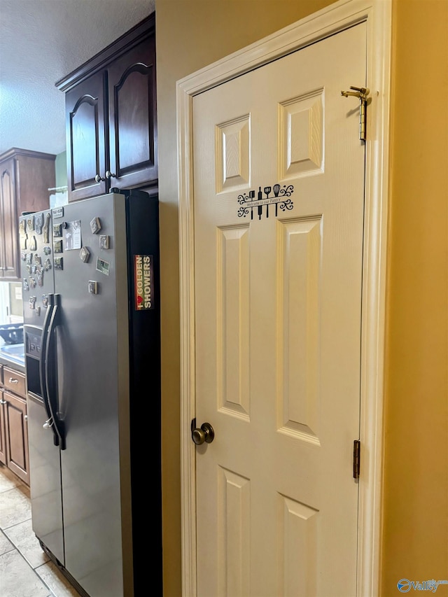 kitchen featuring light tile patterned floors and stainless steel refrigerator with ice dispenser