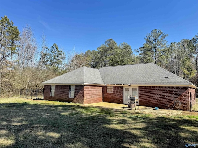 view of front of home featuring a patio area, french doors, and a front lawn