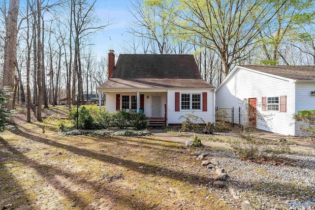 view of front of home featuring a chimney and covered porch
