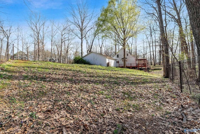 view of yard featuring a wooden deck and fence