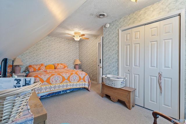 bedroom featuring a textured ceiling, visible vents, wallpapered walls, and carpet floors