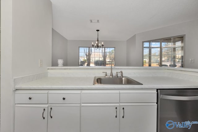 kitchen featuring dishwasher, sink, an inviting chandelier, decorative light fixtures, and white cabinets