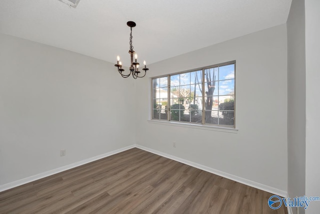 unfurnished room with dark hardwood / wood-style flooring and a chandelier