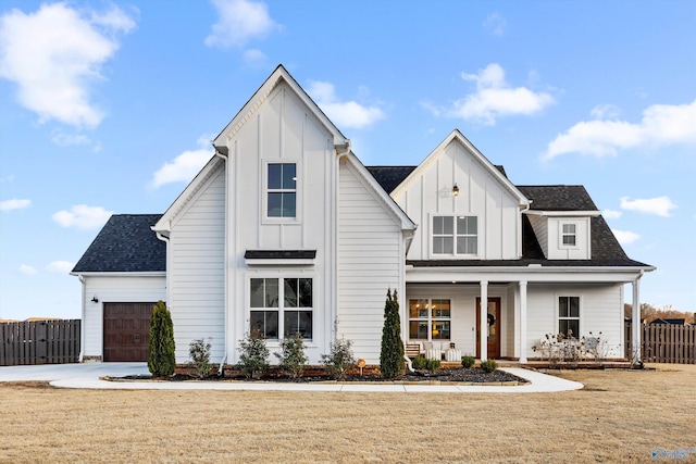 modern farmhouse featuring a garage, a front yard, and covered porch