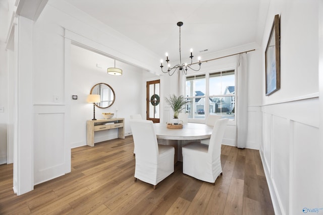 dining area featuring hardwood / wood-style flooring and a notable chandelier