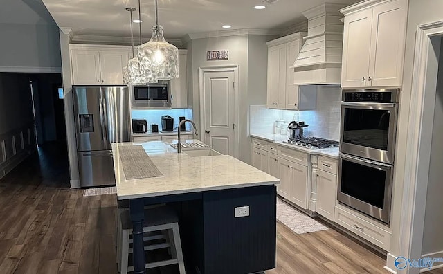 kitchen featuring dark wood-type flooring, a center island with sink, white cabinets, sink, and stainless steel appliances