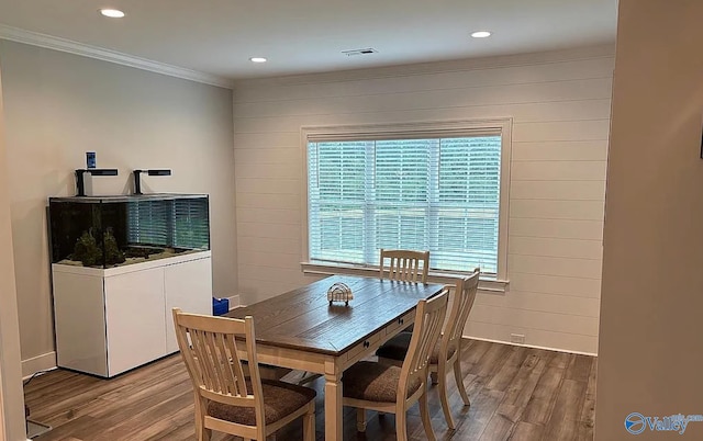 dining area with hardwood / wood-style floors and crown molding