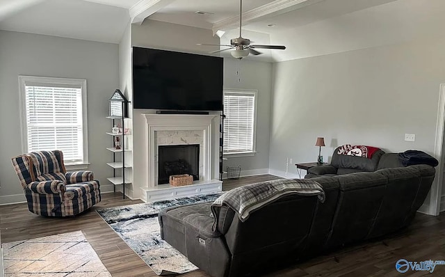 living room with beamed ceiling, dark hardwood / wood-style floors, ceiling fan, and a high end fireplace